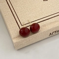 Dettaglio degli orecchini a perno rosso vino retrò con finitura liscia su un libro beige - 12mm / Rosso Borgogna (12mm)