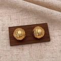 Close-up of golden spherical stud earrings with unique irregular textured surface - Gold C-Shape Texture Earrings