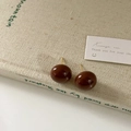 Detailed close-up of dark brown spherical enamel stud earrings on a beige fabric background - 16mm Chocolate