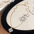 Dettaglio della collana con quadrifoglio dorato e zirconi luccicanti su velluto nero - Collana con Ciondolo a Fiore di Quadrifoglio (B-467)