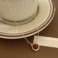 Dettaglio della collana a ferro di cavallo con gemma rossa su tazza da caffè vintage - Collana con Pendente di Perla Premium Oro Rosso