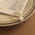 Macro shot of an elegant gold open ring featuring a lustrous white pearl on a ceramic tray - Shell Pearl Gold Ring (C-122)