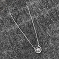Vista de primer plano del colgante de herradura con perla central en cadena de plata - Collar de Plata Con Perla Gris