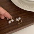 French vintage gold crossover earrings with white pearls on a dark wood background - Double Pearl Ear Buckle Style (D0654)