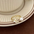 Macro detail of gold-plated fish tail ring with white pearls and sparkling zircons - Fish Tail Micro-pave Zircon Pearl Gold Style