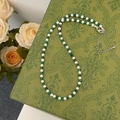 Detail of turquoise and pearl beaded necklace with silver clasp on vintage floral background - Shijia Pearl And Turquoise Meeting Necklace
