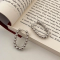 Detailed view of silver oval beaded hoop earrings resting on an open book page - Silver Beaded Western Hoop Earring