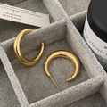 Detailed macro view of chunky gold crescent hoop earrings on a grey velvet jewelry tray - Gold Large (Real Gold Plated)