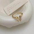 Detail of golden butterfly ring featuring blue and purple zircon on a white plate - Gold Butterfly Open Ring