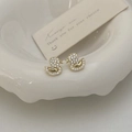 Golden duck stud earrings with pavé zircon stones on a decorative white porcelain dish - White Eyed Duck Stud Earrings