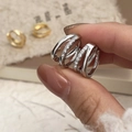 Close-up van drievoudige zilveren oorringen met luxe pavé gezette zirkonia details en glans - Zilver