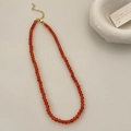 Detailaufnahme der roten Achat-Perlenkette mit goldenem Karabinerverschluss auf Weiß - 4mm Achat / Orangerot (B-186)