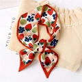 Detail of a white silk scarf with vibrant strawberry and apple prints tied in a bow - Strawberry (LX 12)