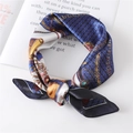 Dettaglio di un foulard quadrato in raso stampato con catene dorate e motivi di carrozze - Blu navy