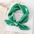 Emerald green satin square scarf tied in a bow knot over a white shirt and magazine - Fruit Green