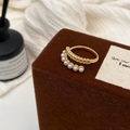 Macro detail of French style golden open ring with textured band and six small white pearls - Gold Wheat Pattern Pearl Ring