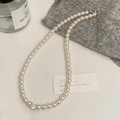 Gros plan d'un collier de perles élégant avec un pendentif en zircone cubique brillant - Collier Perle Blanche Zircon Rond