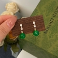 Macro detail of gold green chalcedony drop earrings with sparkling zircon on dark wood - Green Chalcedony Pave Zircon Gold Studs