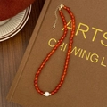 Dettaglio di una collana in agata rossa con una perla grande e chiusura dorata - Collana con Ciondolo a Perla d'Acqua Dolce e Agata Rossa da 6mm
