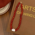 Dettaglio della collana di perle di agata rossa con grande perla barocca e chiusura d'oro - Collana con Ciondolo a Perla Barocca Singola e Agata Rossa da 10mm