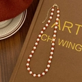 Detailed shot of red agate and white pearl beaded necklace with golden lobster clasp - 4mm Red Agate Crystal Pearl Alternating Necklace