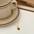 Dettaglio del ciondolo occhio di tigre vintage su catena d'oro sopra una tazza - Collana con pendente occhio di tigre (singola)