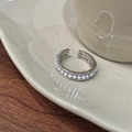 Detailed macro view of adjustable silver ring featuring a row of white pearls on ceramic - Silver Shell Pearl (C-306)