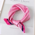 Detail of pink and white houndstooth silk scarf with elegant knotted design and blue border - Rose Red