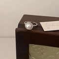 Detail of white pearl ring with halo of sparkling cubic zirconia on a wooden frame - Adjustable Single / Silver Button Pearl Ring