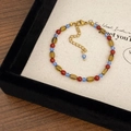 Makro-Detail der roten Achatperlen und blauen Kristalle mit goldenem Verschluss auf Display - Dopamin Roter Achat Armband