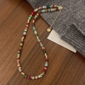 Dettaglio di una collana bohémien in pietre colorate con chiusura dorata su legno - Collana di Perline Colorate Bohémien