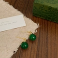 Détail macro de boucles d'oreilles en calcédoine verte et or sur papier vintage - Crochets d'Oreilles Dorés en Calcédoine Verte (A-471)