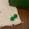 Macro detail of round green chalcedony stud earrings with gold pins on retro paper - 8mm Green Chalcedony Stud Earrings