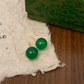 Detailed view of green chalcedony stud earrings with gold plating on textured paper - 10mm Green Chalcedony Stud Earrings