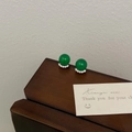 Détail de boucles d'oreilles en calcédoine verte et zircons sur une surface en bois - Calcédoine Verte Zircon Boucles d'Oreilles Clous