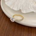 Detail van gouden verstelbare ring met grote zirkonia en glanzende pavé-diamanten - Goud