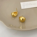 Macro dettagliata di orecchini a goccia in oro spazzolato con finitura opaca - Oro