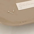 Orecchini a lobo minimalisti in argento con piccole perline su un vassoio di ceramica - Orecchini a Bottone a Sfera Argentati
