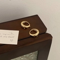 Dettaglio ravvicinato di orecchini a cerchio dorati vintage con piccole perle - Oro