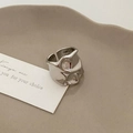 Detail of silver irregular liquid texture ring on beige ceramic display tray - Silver Solid