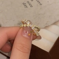 Dettaglio macro del set di anelli dorati con cuori e zirconi lucidi incastonati - Anello in oro aperto in zirconia a cuore (C-31)