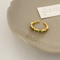 Detailed view of adjustable gold ring with five square green zircons on ceramic tray - Gold Green Zircon Open Ring