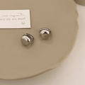 Dettaglio di orecchini a cerchio in argento a forma di ciottolo su vassoio in ceramica - Argento