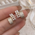 Primo piano dettagliato di orecchini a perno francesi in oro e perle con zirconi e design curvo - Oro (Placcato Oro Vero)