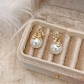 Gros plan de boucles d'oreilles géométriques dorées avec cristaux et perles blanches - Ligne d'or Micro-incrustation de Zircon Boucles d'oreilles en Perles de Coquillage Blanches