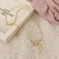 Detail van de gouden slangketting met een strikhanger en glinsterende strassteentjes - Goud