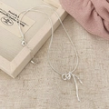 Detailopname van de zilveren strik hanger ketting met een elegante slangenketting - Zilver