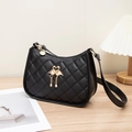 Bolso de hombro negro con hebilla de cisne dorada y textura acolchada sobre madera - Negro