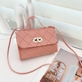 Bolso rosa acolchado con cierre dorado y asa superior sobre escritorio blanco - Rosa