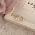 Detalle de anillo dorado ajustable con pequeñas perlas blancas y diseño minimalista - Banda Fina de Perlas Abierta (Dorado) / Dorado